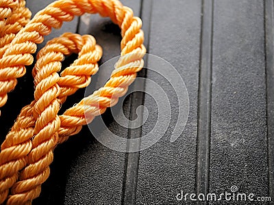 Bright orange braided nylon rope in tangled coil black background Stock Photo