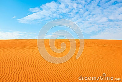 Bright orange color rippled desert sand and clear blue sky for a warm hot summer background Stock Photo