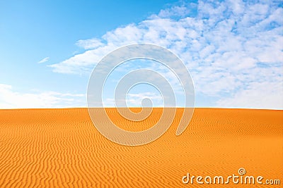 Bright orange color rippled desert sand and clear blue sky for a warm hot summer background Stock Photo