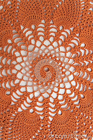 Bright orange crocheted product. Openwork napkin for decor on white background. Knitted lace pattern. Vertical frame Stock Photo