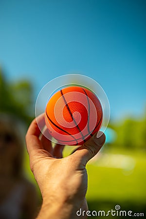 Bright orange mini basketball in a hand Stock Photo