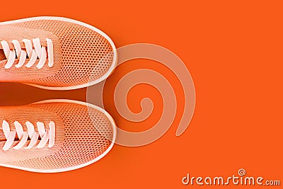 Bright orange sneakers on an orange background. Stock Photo