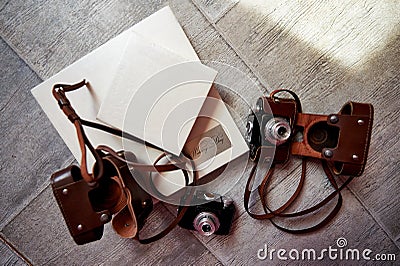 Bright photobook with leather light cover lying on the floor. The next two camera in brown case Stock Photo