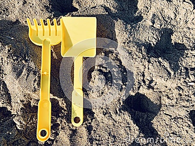 Bright plastic children`s toys in the sand. Concept of beach recreation for children. Top view. Space for text Stock Photo