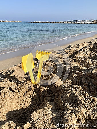 Bright plastic children`s toys in the sand. Concept of beach recreation for children. Top view. Space for text Stock Photo