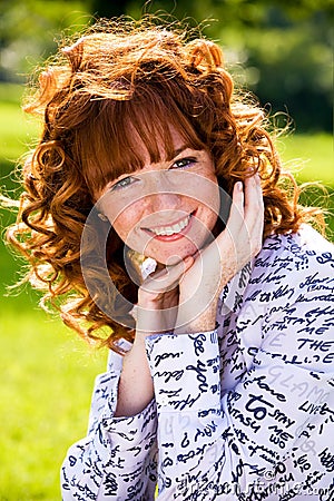 Bright portrait of red-haired young woman outdoors Stock Photo