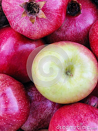 Bright red apples and pomegranates closeup with standout green apple Stock Photo
