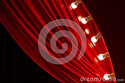 Bright red curtain with multiple small white bulbs along the edge hanging down Stock Photo