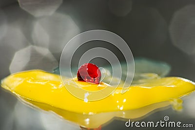 Bright red medical capsule on yellow ointment Stock Photo
