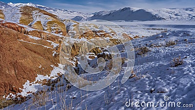 Bright red-orange hills and snow-capped mountains Stock Photo