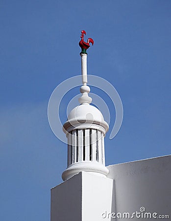 Red Rooster Weather Vane on Algarve Chimney Stock Photo