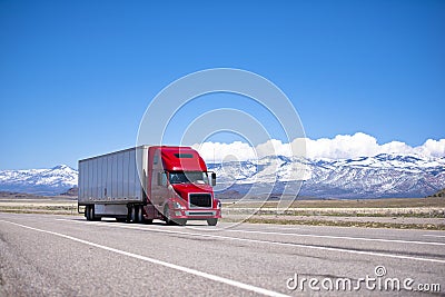 Bright red semi truck modern transportation on spectacular highway Stock Photo