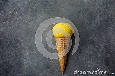 Bright Ripe Yellow Lemon in Waffle Ice Cream Cone on Dark Concrete Stone Background. Summer Fruits Dessert Freshness Vitamins Stock Photo