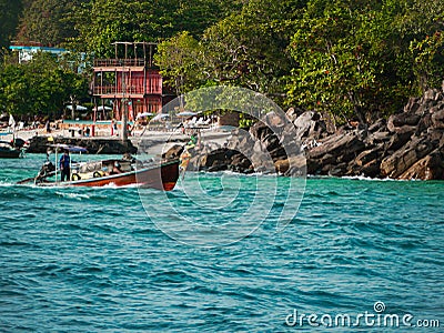 Bright sea with a shore full of houses and rocky mountains in the background Editorial Stock Photo