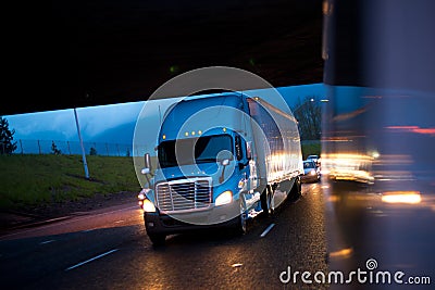 Bright semi truck in raining night lights on highway Stock Photo