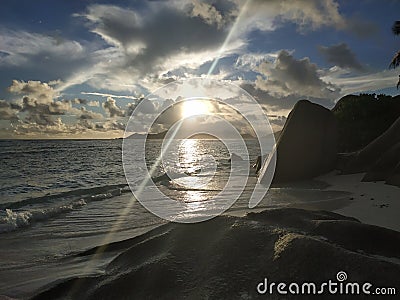 Bright shining sunset at Ladigue Seychelles with light ray Stock Photo