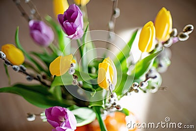 Bright spring bouquet of yellow and purple tulips and branches pussy willows. Easter arrangement of fresh flowers Stock Photo