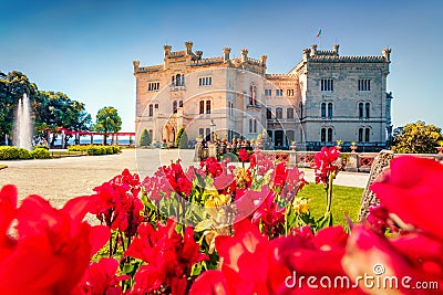 Bright summer view of Miramare Castle with blooming red tulip flowers on foreground Editorial Stock Photo