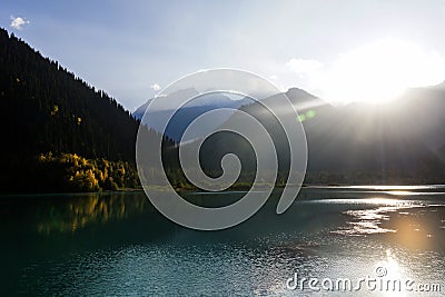 Bright sun rays over mountain lake Stock Photo