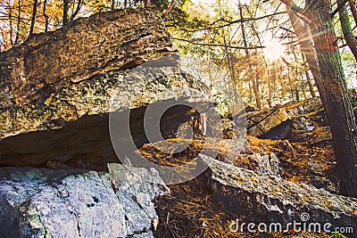 The Sun Sets through the Trees Over a Beautiful Rock Formation Stock Photo