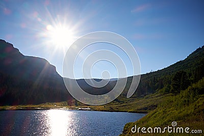 Bright sunburst over a Colorado mountain lake Stock Photo