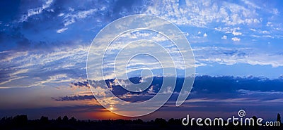 Bright sunlight through the clouds against a breathtaking evening sky at sunset. Stock Photo