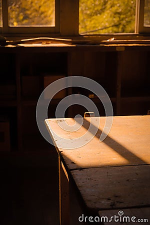 Bright and sunny interior shot of a room with a large window showcasing a wooden table Stock Photo