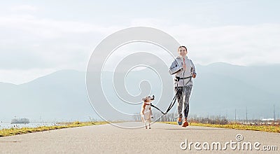 Bright sunny Morning Canicross exercises. Female runs with his beagle dog and happy smiling Stock Photo