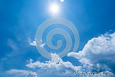 Bright sunshine with sun flares and clouds on clear blue sky background, hot summer concept Stock Photo