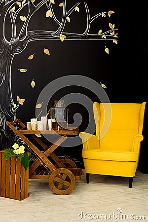 Bright yellow armchair next to the wooden carriage Stock Photo