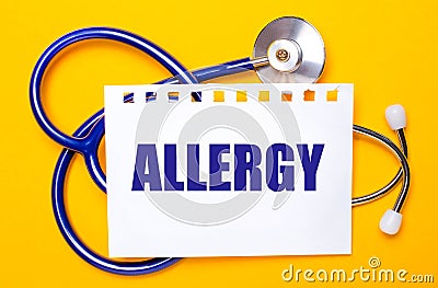 On a bright yellow background, a blue stethoscope and a sheet of paper with the text ALLERGY. Medical concept Stock Photo