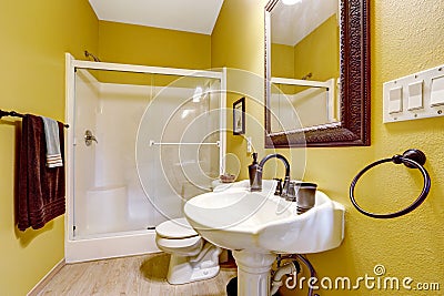 Bright yellow bathroom with glass door shower Stock Photo