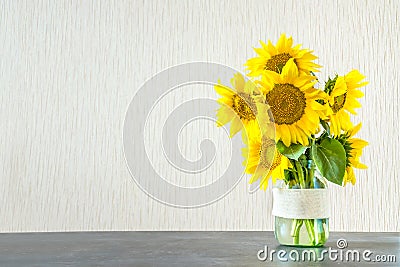 Bright yellow big sunflowers in glass vase on dark table on light texture background. Mockup banner with sunflower bouquet with c Stock Photo