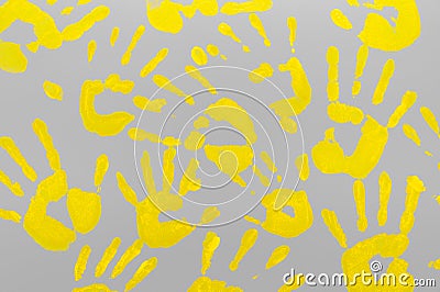 Bright yellow family handprints on a gray background. Positive and hope Stock Photo