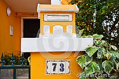 A bright yellow little house is a mailbox in a lisbon in the leaves of a tree. Editorial Stock Photo