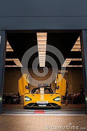 Yellow McLaren 765LT, Open Doors, Showcased in a Chic Tuning Garage Editorial Stock Photo