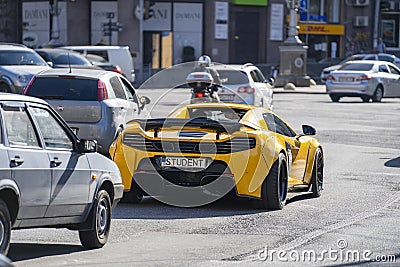 Bright yellow Mclaren sports race car with license plate student on the main street of Kiev Khreshchatyk , Ukraine Editorial Stock Photo