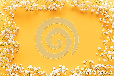 Bright yellow paper background with soft little white flowers, welcome spring concept. Happy Mothers Day, Womens Day greeting card Stock Photo
