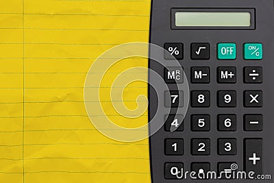 Bright yellow ruled line notebook crumpled paper with a calculator Stock Photo