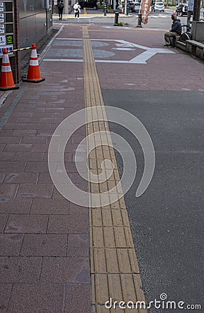 Bright yellow tactile footpath for people who have visually impaired on the walkway. Stock Photo