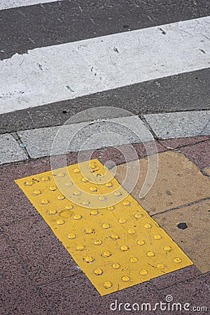 Bright yellow tactile footpath for people who have visually impaired on the walkway. Stock Photo