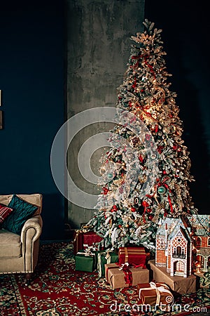 Brightly christmas tree in a room with red carpet with lots of gifts under it. New year holidays Stock Photo