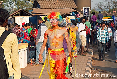 Brightly colored actor with psychedelic wig walking in crowd of people at the traditional Goa carnival Editorial Stock Photo