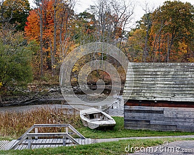 Abandoned wood boat sits in front of the iron warehouse at the Saugus Iron Works Stock Photo