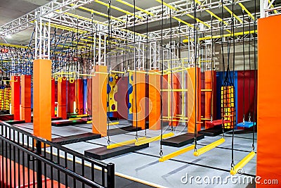 Brightly coloured interior ninja warrior parkour gym obstacle course with aerial netting Stock Photo