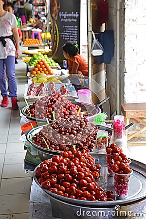 Brightly coloured pickled Chinese Dates sold with other fruits by Vendor along the outdoor corridor of Bogyoke Market Editorial Stock Photo