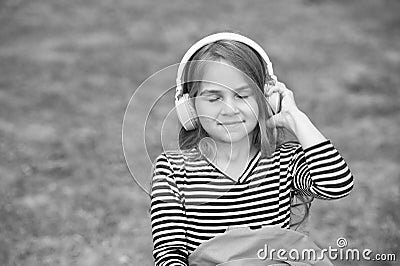Bring music to life. Little child listen to music with closed eyes. Small girl wear headphones playing music. New Stock Photo
