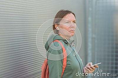Urban brisk walker female listening music on earphones Stock Photo