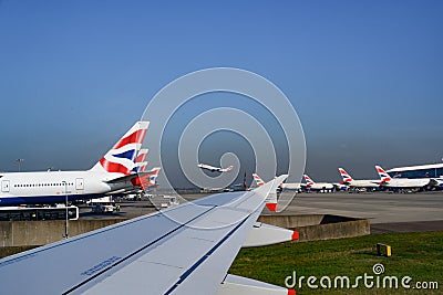 British Airways planes in line on ground in Heathrow Airport. British Airways aircrafts with Union Jack on tail. Editorial Stock Photo