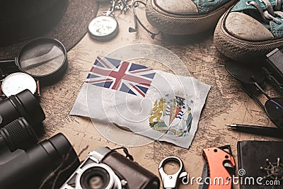 British Antarctic Territory Flag Between Traveler`s Accessories on Old Vintage Map. Tourist Destination Concept Stock Photo